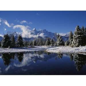 Clouds and Snow Covered Pine Trees and Peaks are Reflected in Water of 